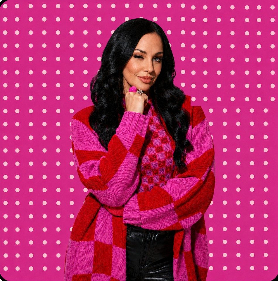 Brea Ballard, founder of House of Icon, in a pink and red checkered cardigan against a hot pink polka dot backdrop